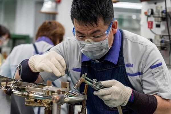 Ein Handwerker, der Metallteile mit bleifreiem Lot lötet.