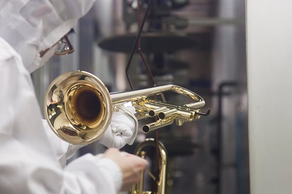 Ein Arbeiter reinigt ein Musikinstrument während des Waschvorgangs in einer Yamaha-Fabrik.