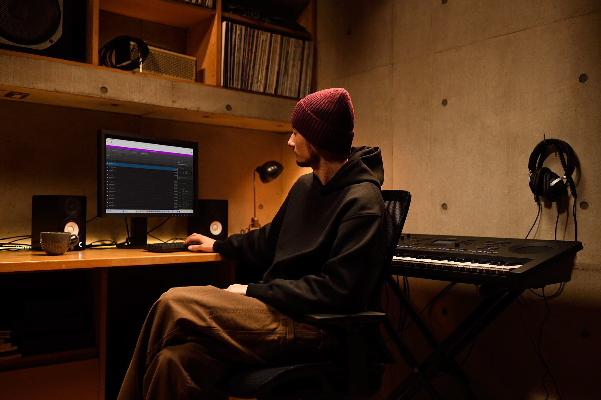 Ein Musik-Arbeitsplatz zu Hause mit einem Computer und einem Keyboard, an dem ein Keyboarder in seinem Heimstudio arbeitet