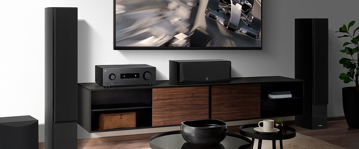 Der RX300A, ein Center-Lautsprecher, Front-Lautsprecher und ein Subwoofer in einem Raum.