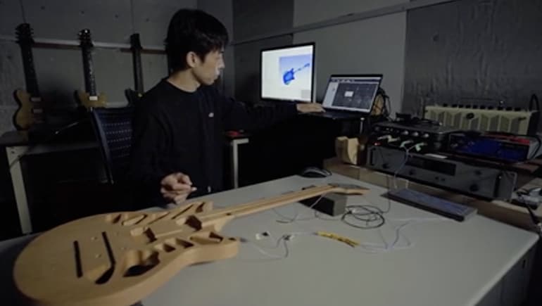 Research and development staff analyzing a guitar body with special equipment.